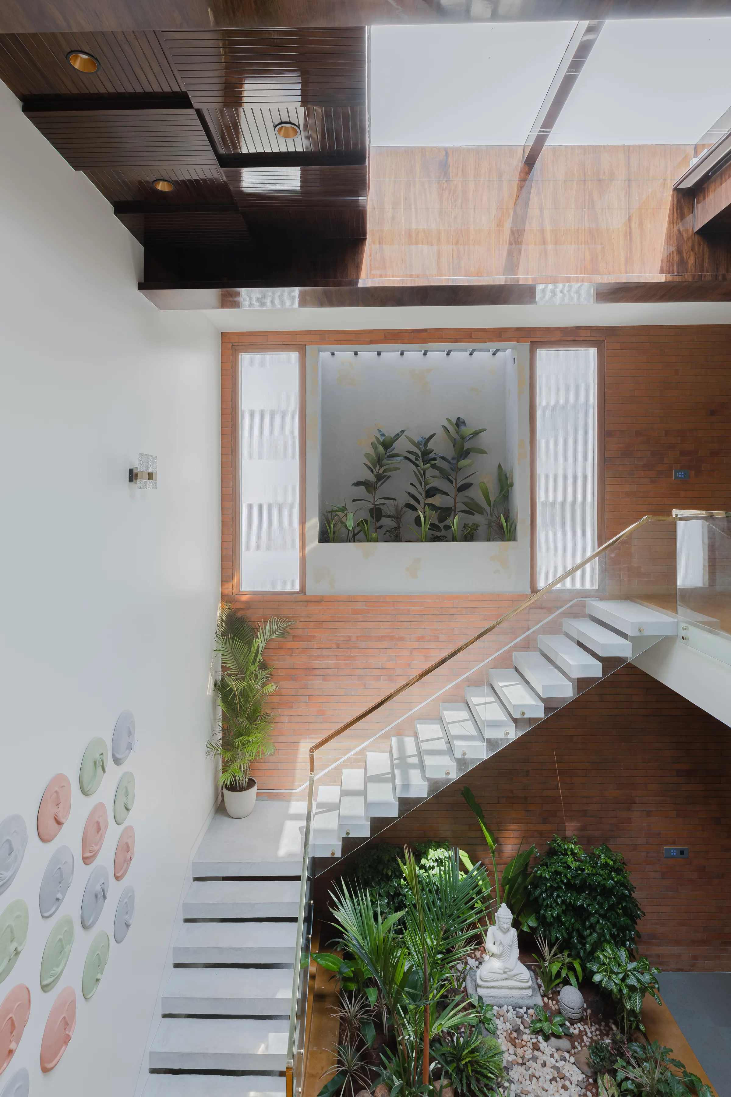Courtyard staircase, indoor planting and a skylight at Madhura Maanasa