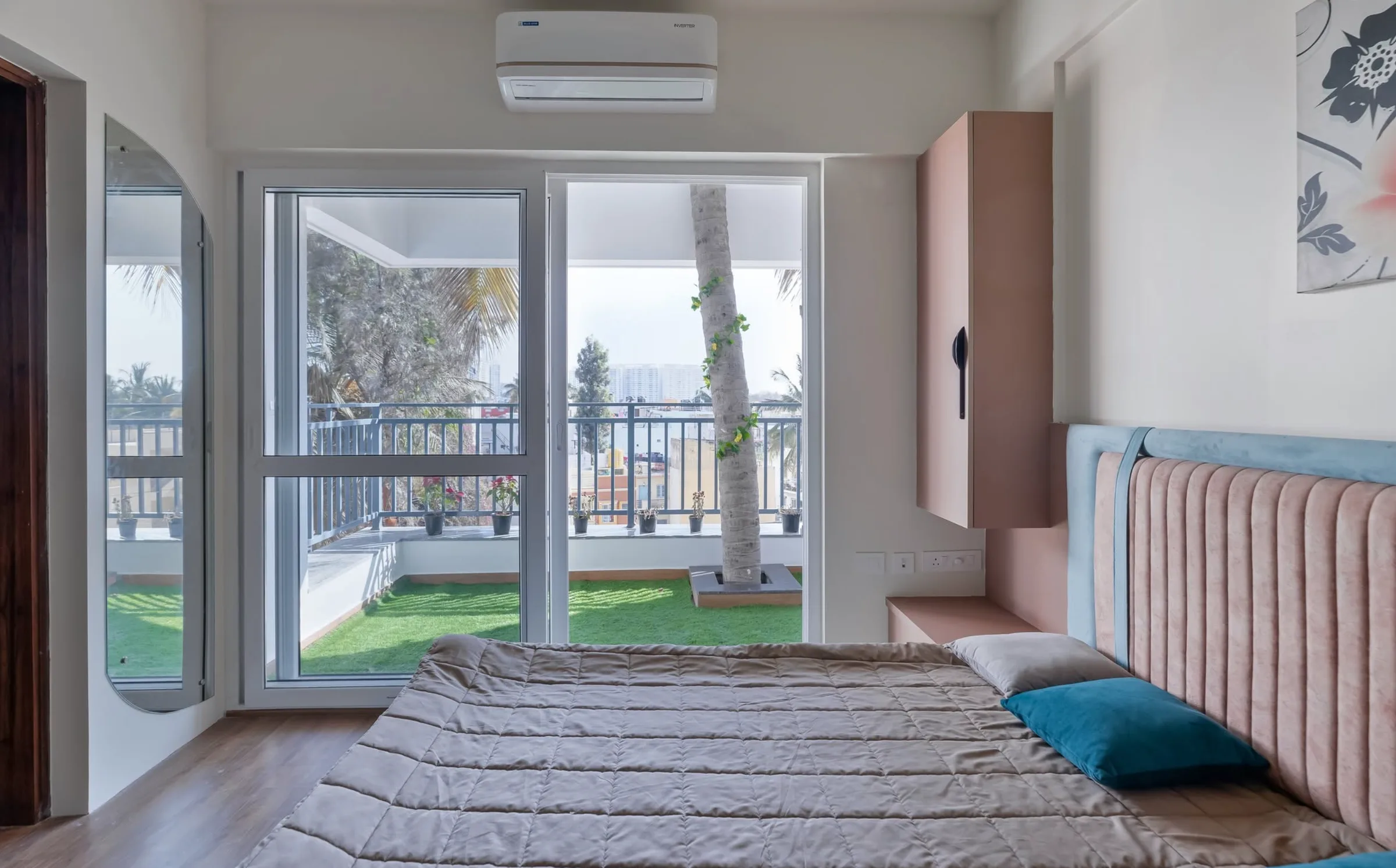 Bedroom with a blush headboard and a balcony at the JP Nagar apartment