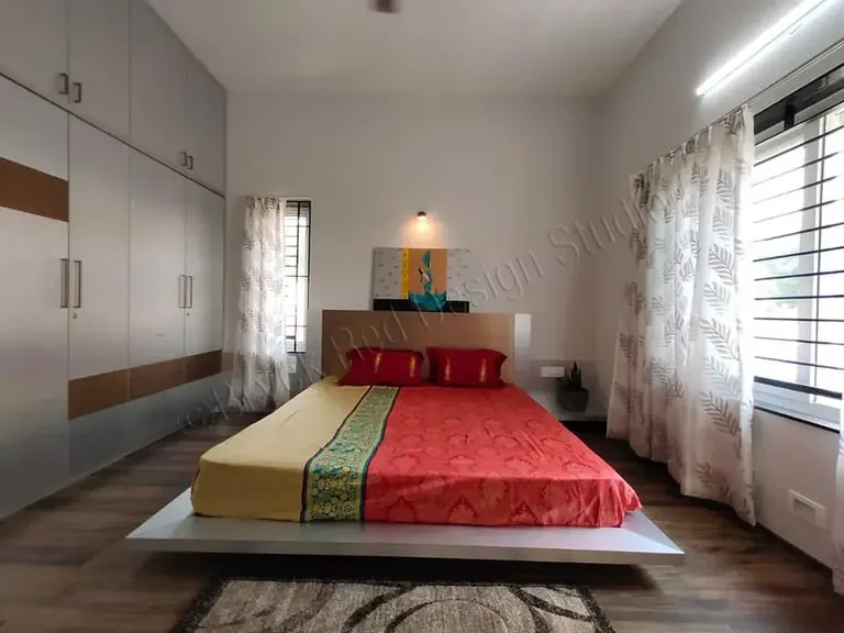 Bedroom with a red accent wall and framed artwork.